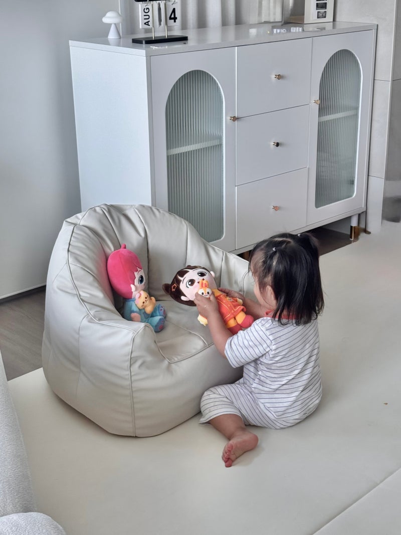 Child playing with Bebefinn Magnetic Cuddle Plush toys on a bean bag