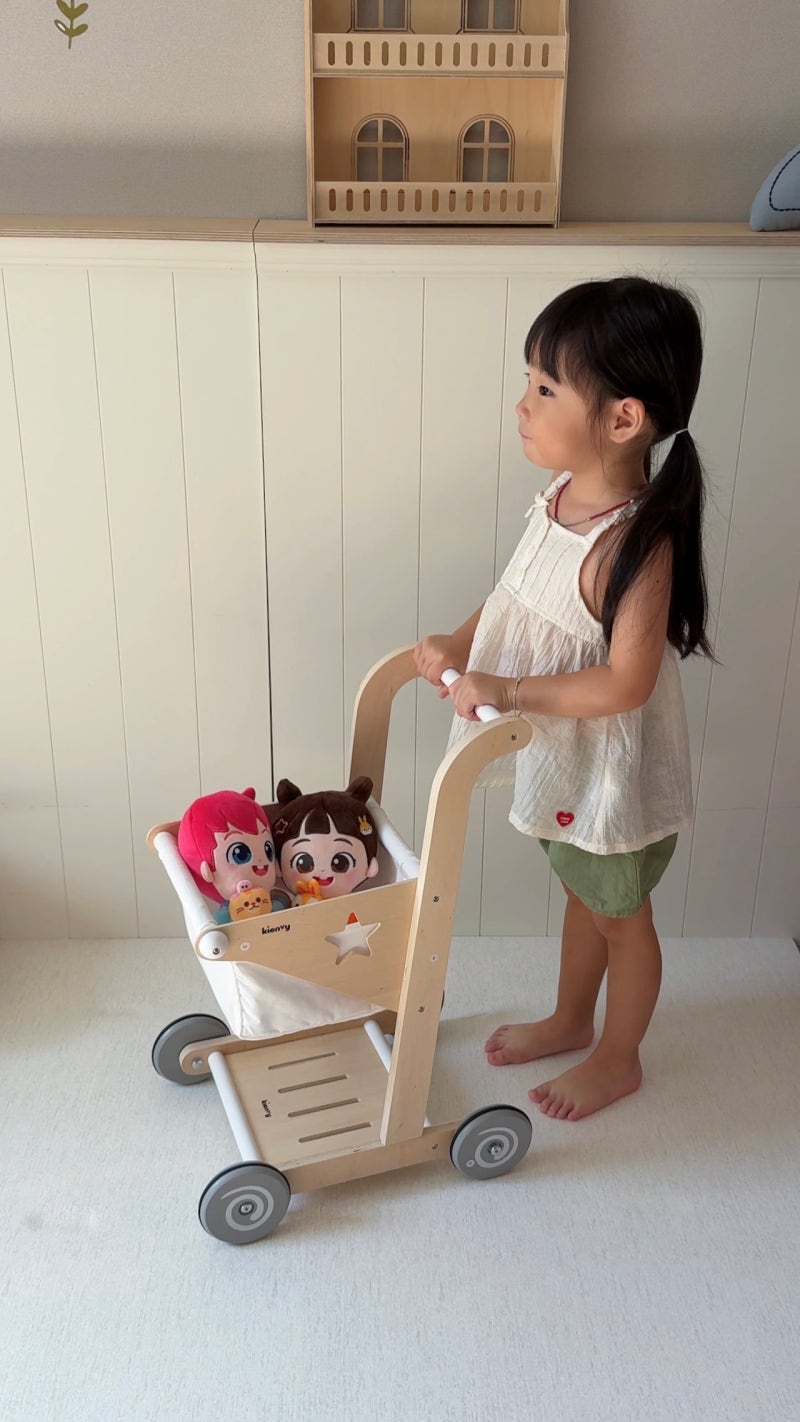Child pushing a toy stroller with Bebefinn Magnetic Cuddle Plush toys inside